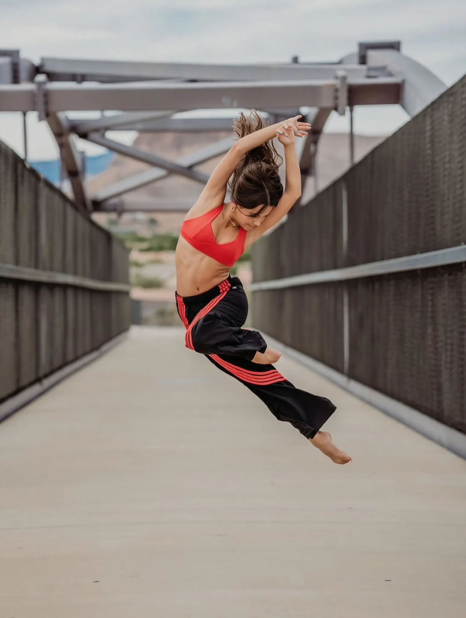 Evolve dancer mid-air leap on a bridge
